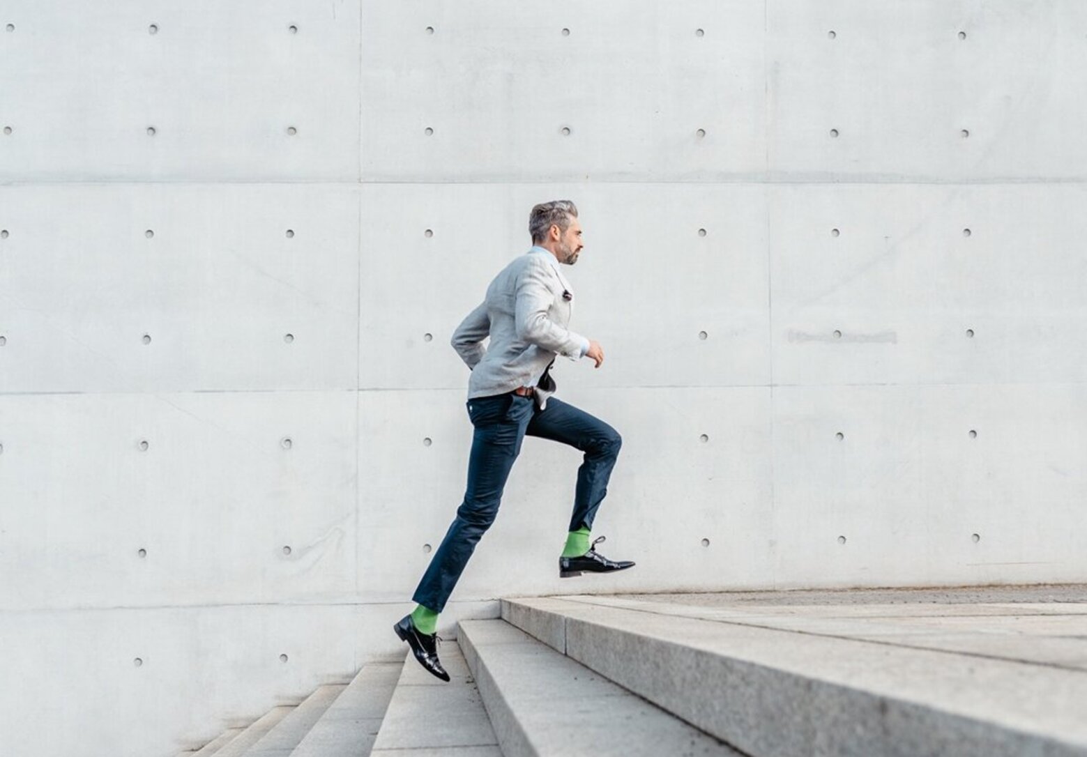 elegant bearded businessman running up stairs outdoors