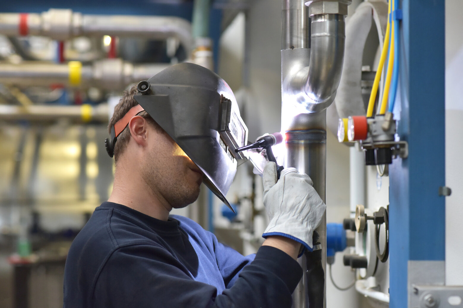 welder works in steel construction and repairs an industrial plant